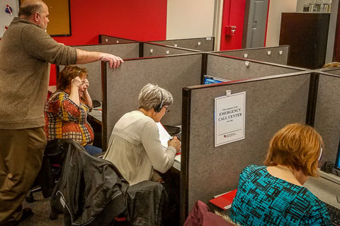 Emergency Call Center members work in their cubicles.